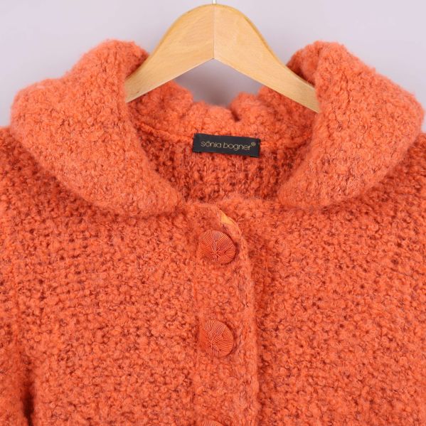 Närbild på krage och knappar av den orange koftan