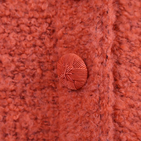 Närbild på en av de runda knapparna i garn