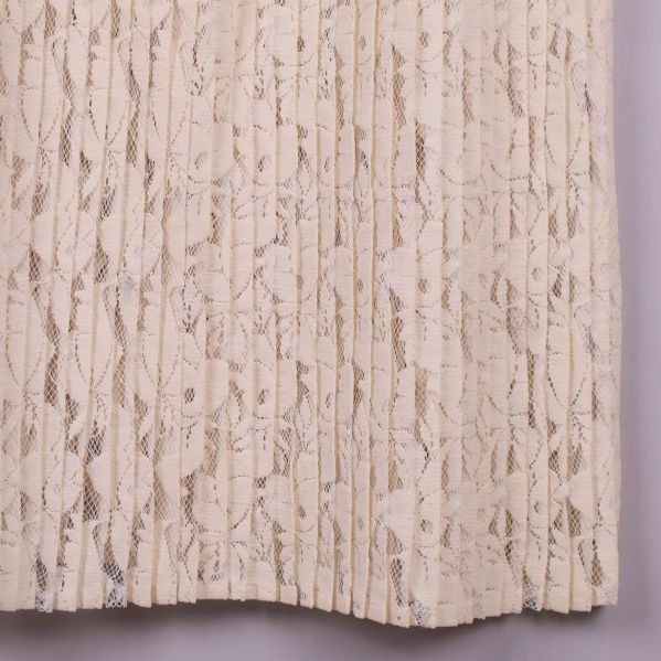 Blommönstrad spetsdetalj i närbild på kjolen