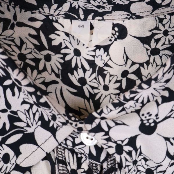 Närbild på blommönstrat tyg och storleksetikett 44