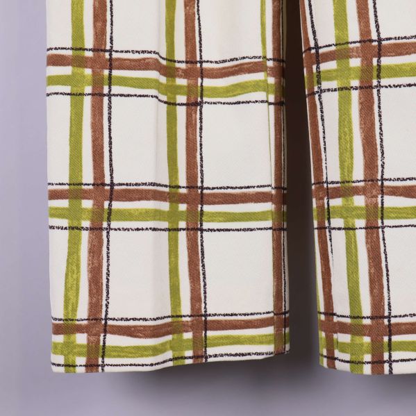 Närbild på ben med rutigt mönster i grönt och brunt