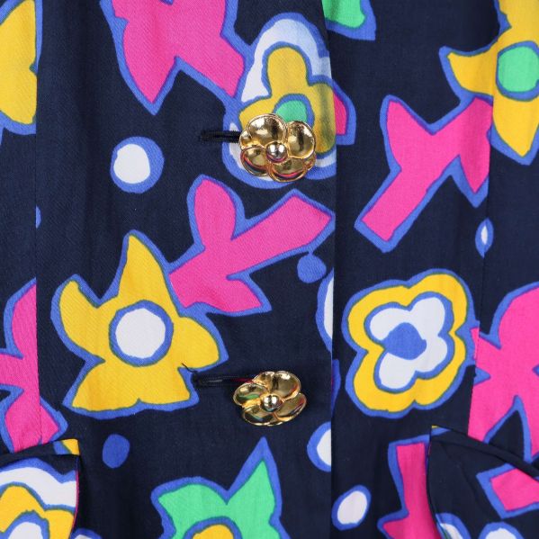 Närbild på guldknappar och blommigt tyg