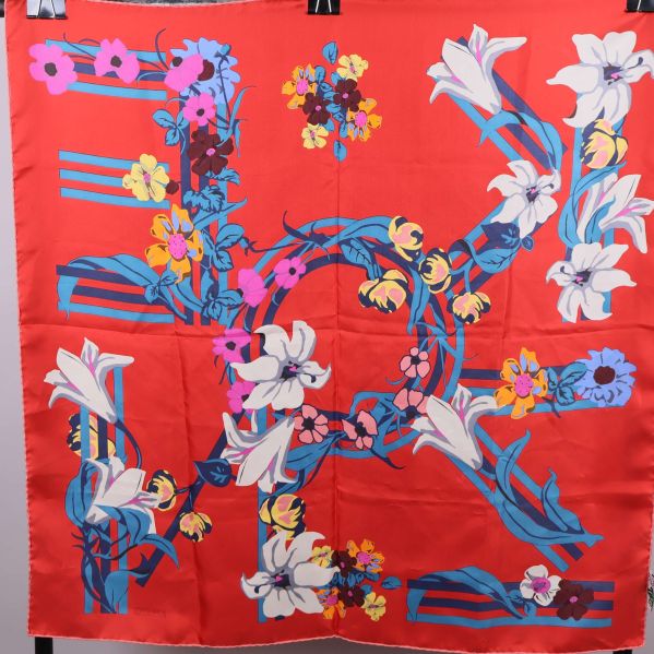 Scarf med röd botten och färggrant blommönster utbrett