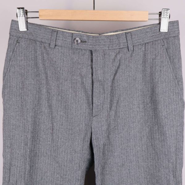 Närbild på byxlinning med knapp och bälteshällor