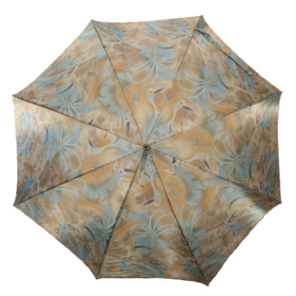 Paraplyet är utfällt med mönster av fåglar och blad