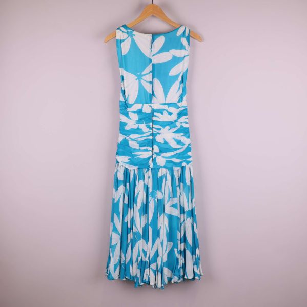 Baksida av blåvit plisserad klänning med blommönster