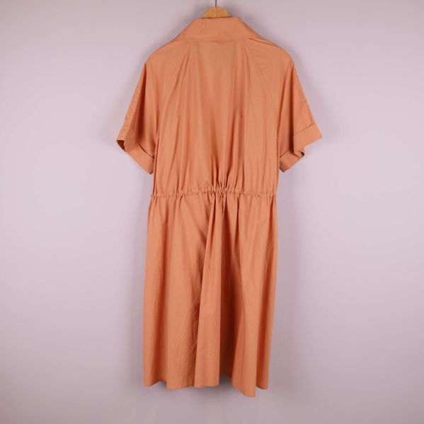 Baksida av aprikos kortärmad klänning på galge