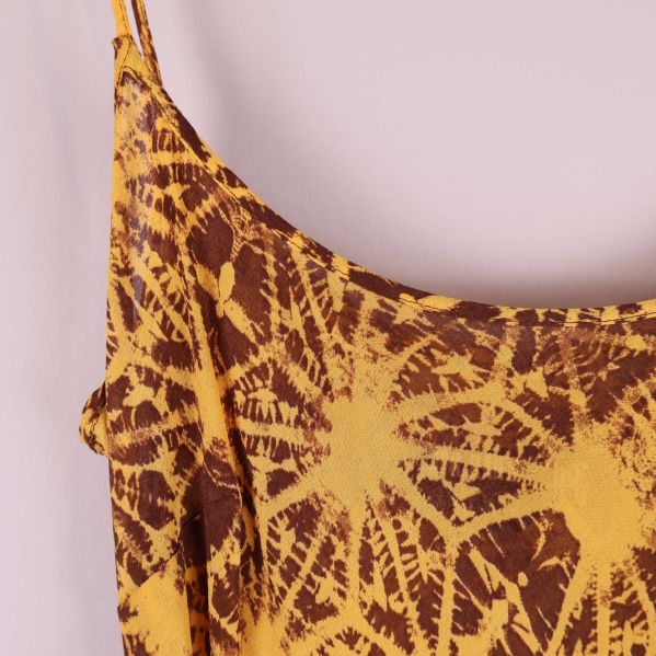 Närbild på axelband och mönster på klänningen