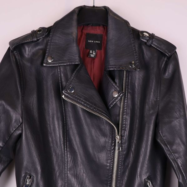 Detaljbild på axlar och krage med nitar och dragkedja