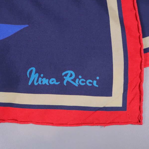 Närbild på Nina Ricci-signatur i hörnet av scarfen