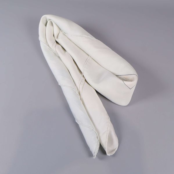 Scarf i vit siden hopvikt på ett bord
