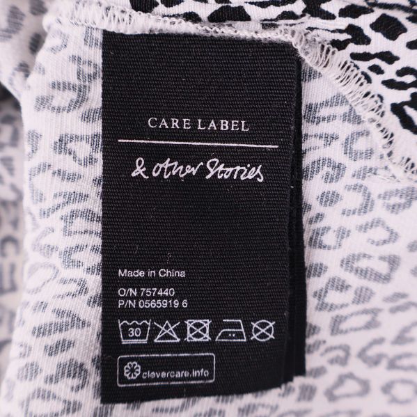 Svart etikett med & Other Stories logga och tvättråd