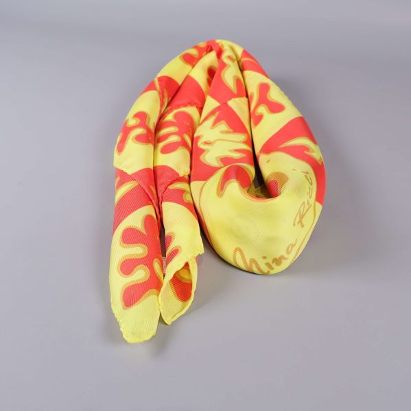 Scarf ihoprullad på ljus yta, visar färg och tyg