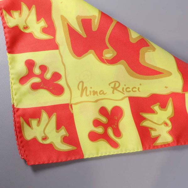Hörn av scarfen med Nina Ricci-logotyp och tydliga mönster