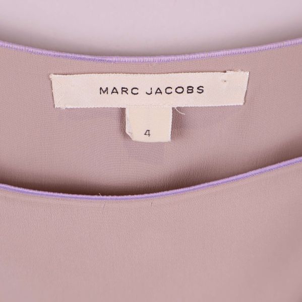 Närbild av vit etikett med Marc Jacobs och storlek fyra