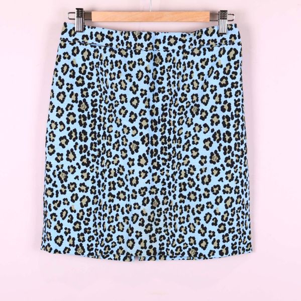 Framsidan av ljusblå kjol med leopardmönster upphängd på galge