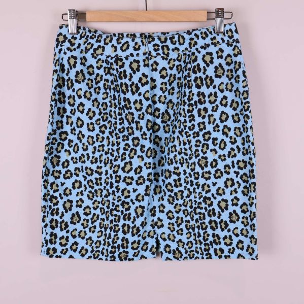 Baksidan av ljusblå kjol med leopardmönster på galge