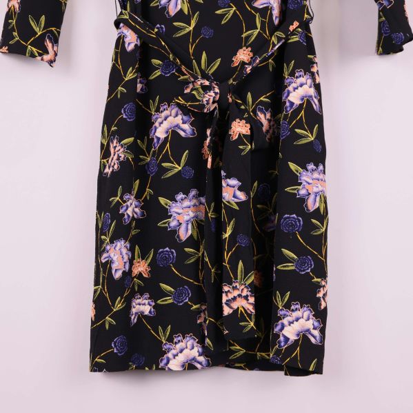 Närbild på kjoldelens knytband och blommönster