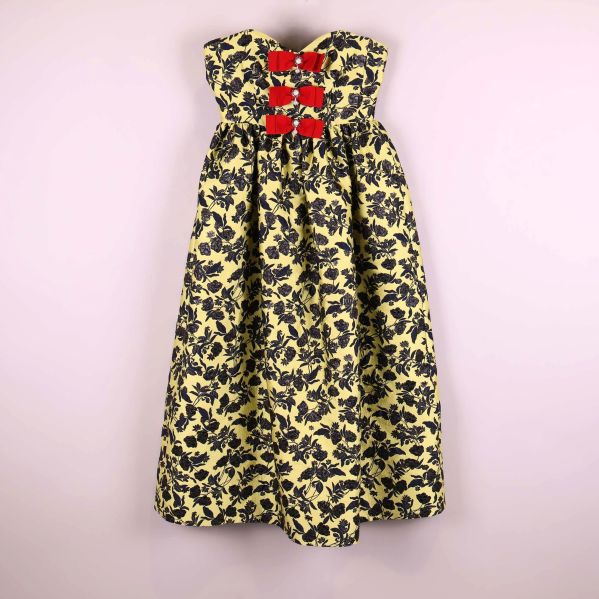 Axelbandslös blommig klänning med röda rosetter framtill