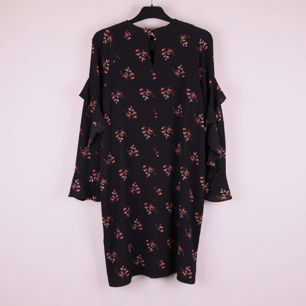 Klänningens baksida visar volanger och blommigt mönster