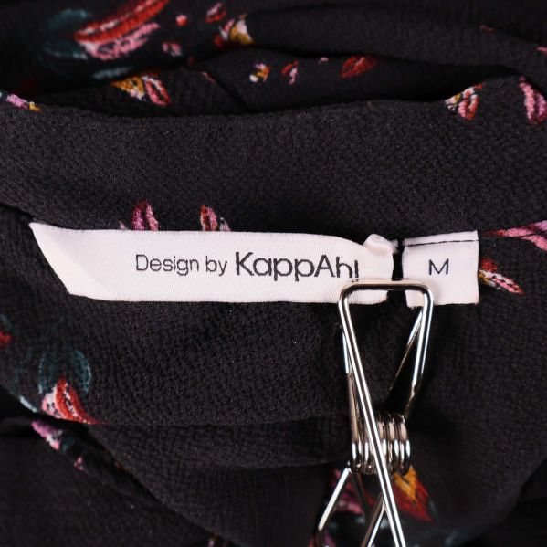 Närbild på etikett med text Design by KappAhl och storlek M