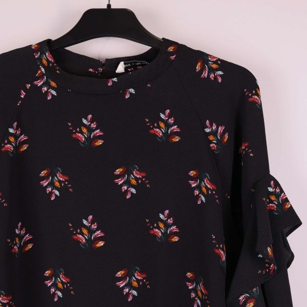 Närbild på klänningens överdel och blommigt mönster