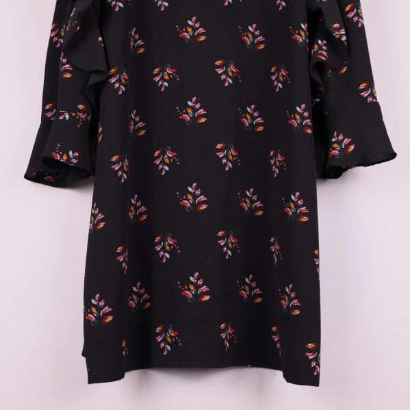 Närbild på nederdelen av klänningen och det blommiga mönstret