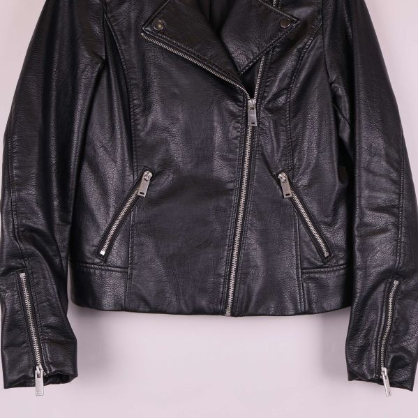 Närbild på fickor och dragkedjor på svart jacka