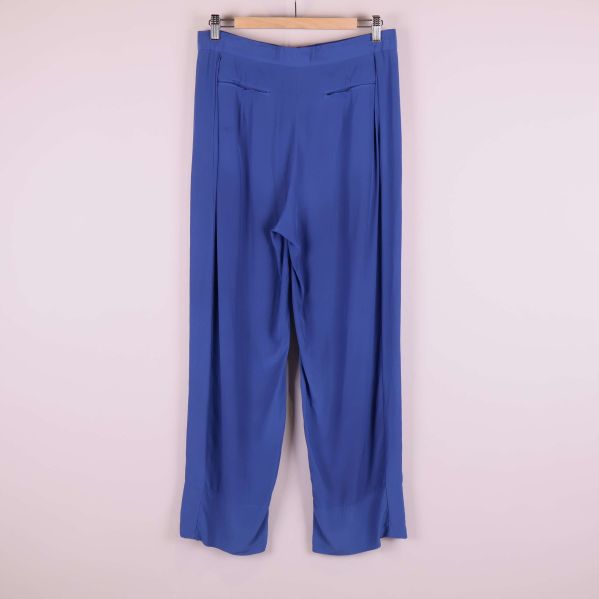 Baksida av blå vida byxor på galge