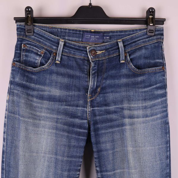 Jeansens midja och fickor med knappdetalj