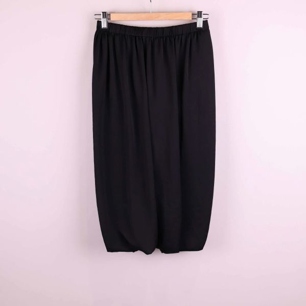 Svart byxkjol med avslappnad passform hängande på trägalge