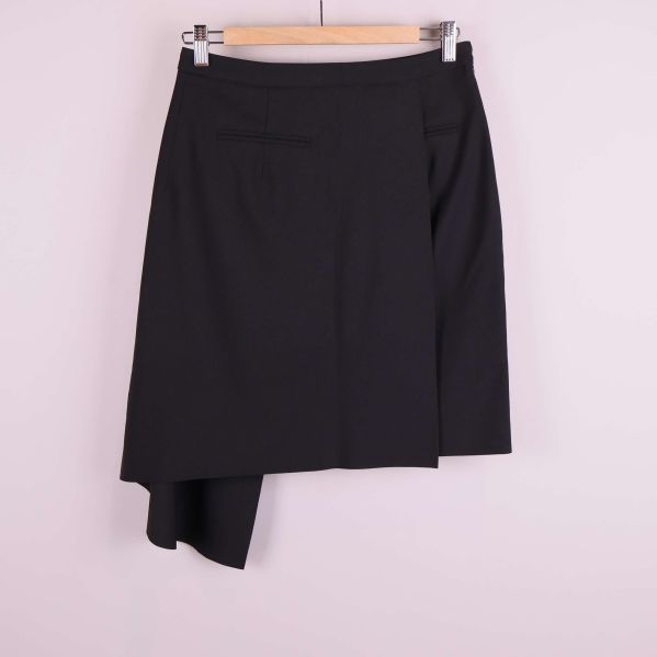 Baksida på svart asymmetrisk kjol med fickor