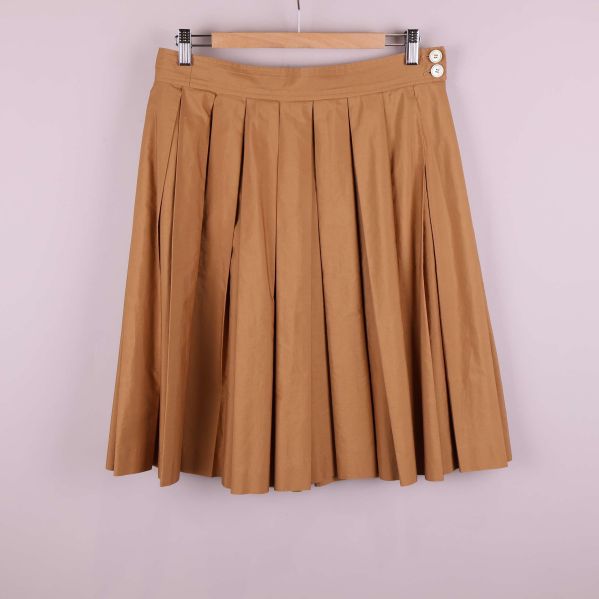 Framsida av beige plisserad kjol med knappar och veck