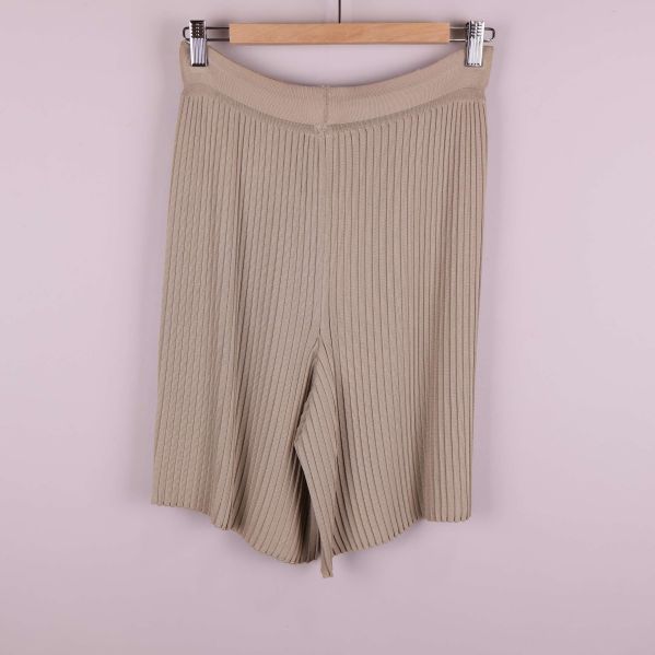 Beiga plisserade shorts fotograferade bakifrån på galge