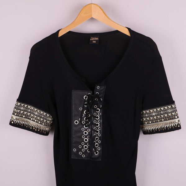 Närbild av toppens framsida med snörning och nitar