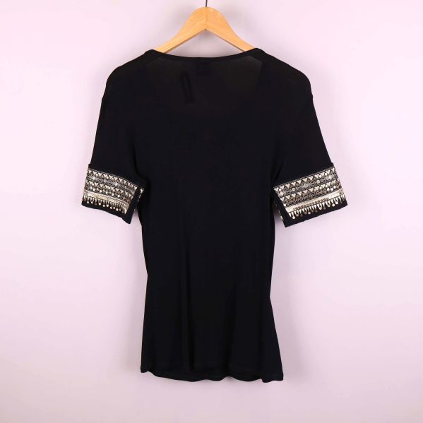 Baksidan av svart topp med dekorerade ärmslut