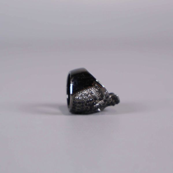 Skulpterad dödskalleprofil på ringens sida