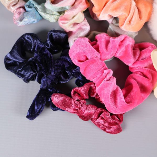 Närbild på rosa och mörkblå scrunchies i sammetstyg