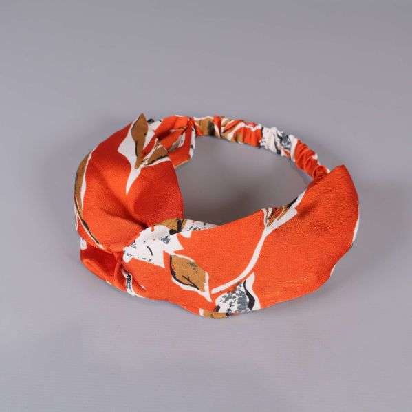Orange hårband med vita och bruna blommiga detaljer