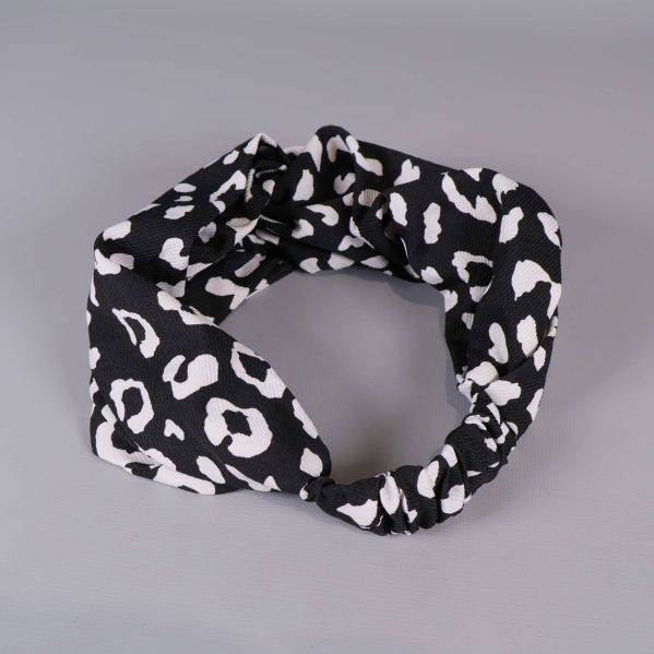 Detaljbild på svartvitt hårband med grafiskt mönster