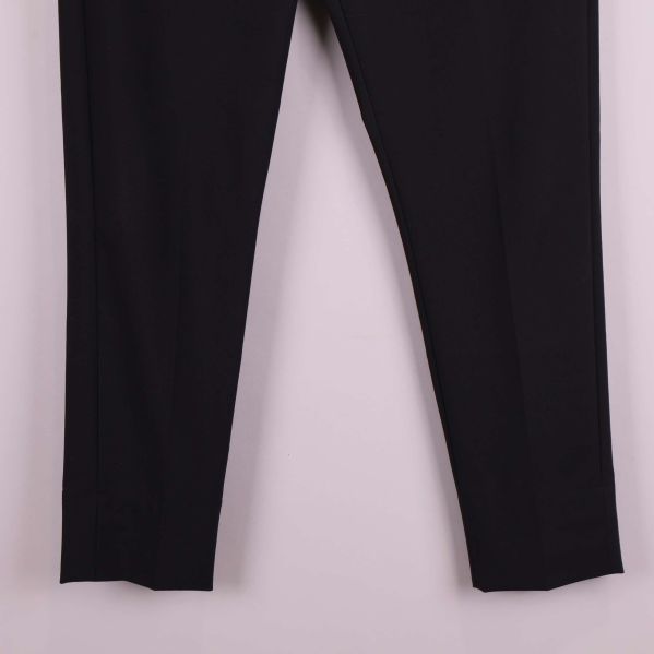 Närbild på benslut av svarta kostymbyxor