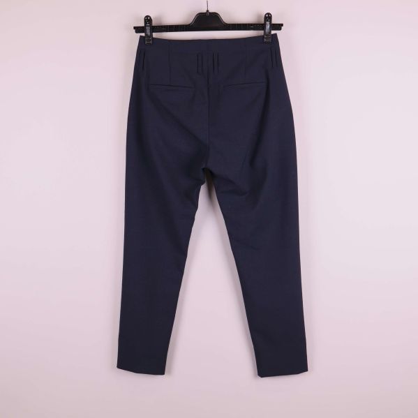 Mörkblå byxor bakifrån på galge med passpoalfickor