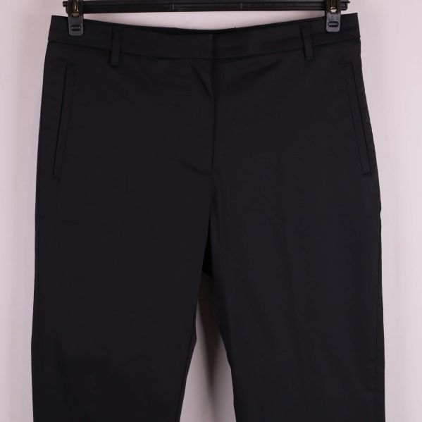 Framdel av svarta byxor med fickor och bälteshällor