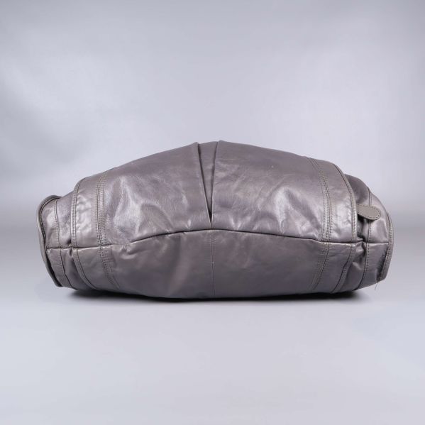 Undersidan av väska i grått läder med tydlig söm