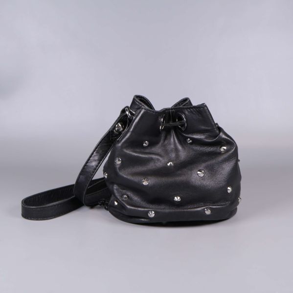 Bucket bag sedd bakifrån med dekorativa nitar och lång rem