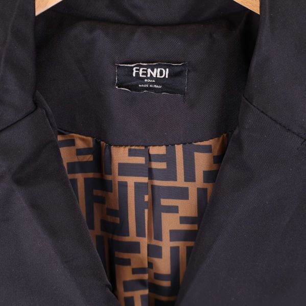 Närbild på Fendi-logotyp och mönstrat brunt innerfoder i kappan