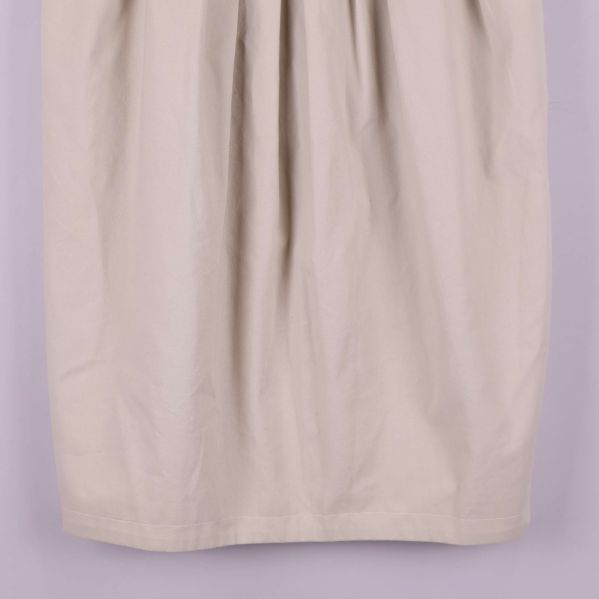 Närbild på kjolens nederdel i beige tyg