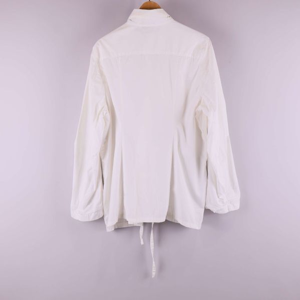 Baksida av vit skjorta med lång ärm och knytskärp