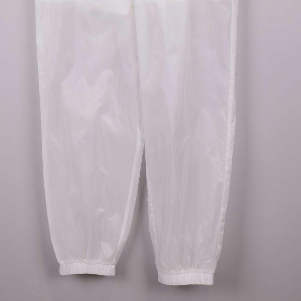 Vita byxben med elastiska avslut i närbild