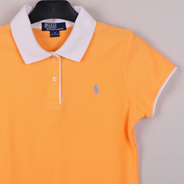 Närbild på vänster bröst och krage med blå logga